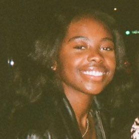 A woman in a leather jacket smiling at the camera