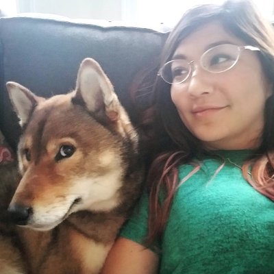 A woman sitting on a couch with a dog