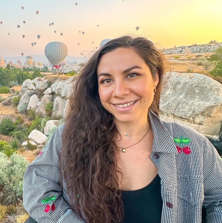 A woman standing in front of a bunch of hot air balloons
