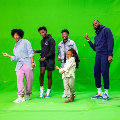 A group of people standing in front of a green screen